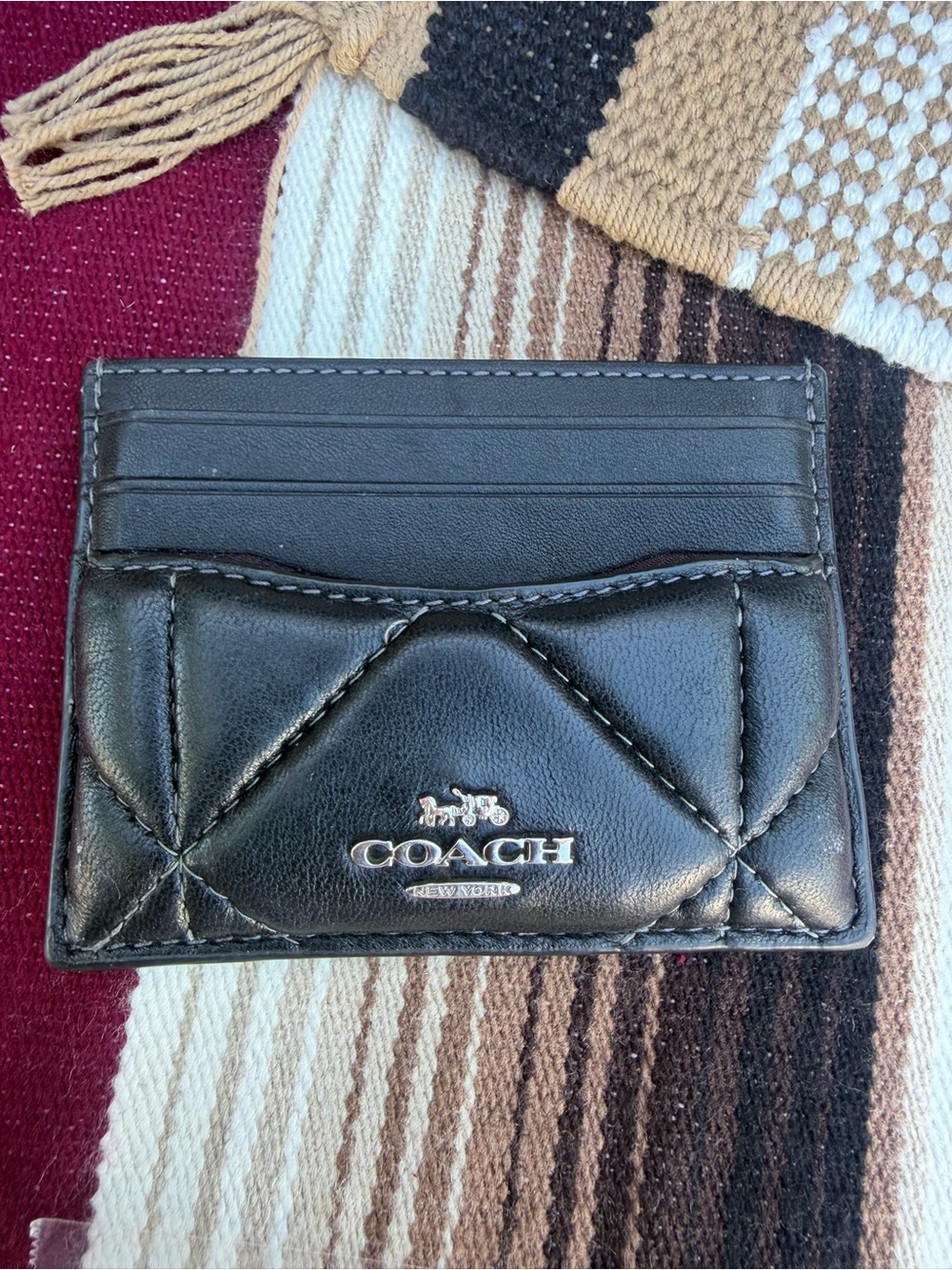 Black Coach leather card holder with quilted stitching